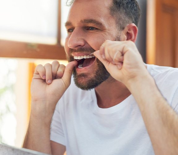 Man using dental floss to clean his teeth