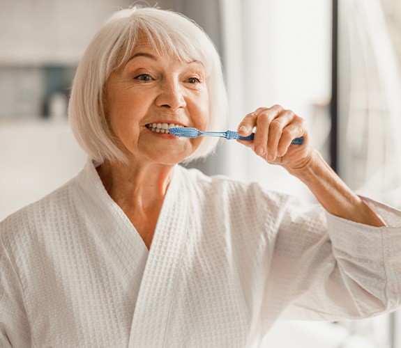 Older woman brushing her teeth