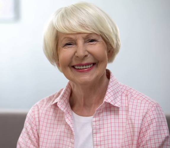 Older woman smiling and pleased with new teeth
