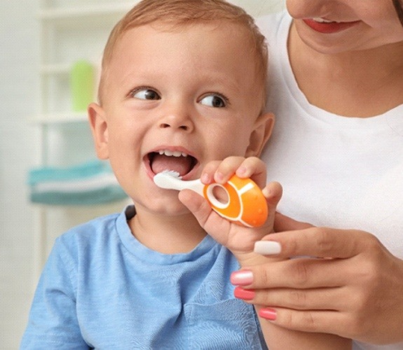 Little boy smiling and putting toothbrush in mouth