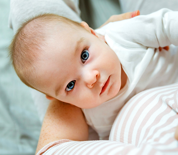 Mohter holding baby after frenectomy treatment