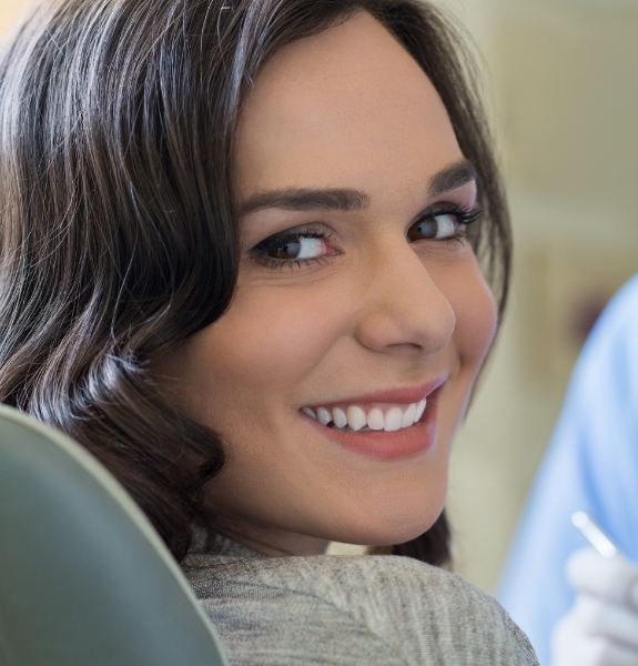 Woman in dental chair smiling at periodontist