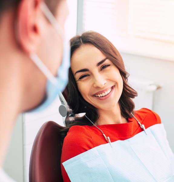 Woman in dental chair smiling at her orthodontist