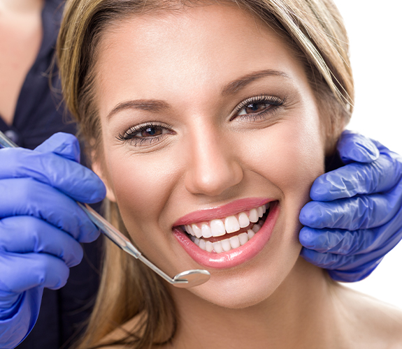 Patient receiving dental exam to prevent dental emergencies
