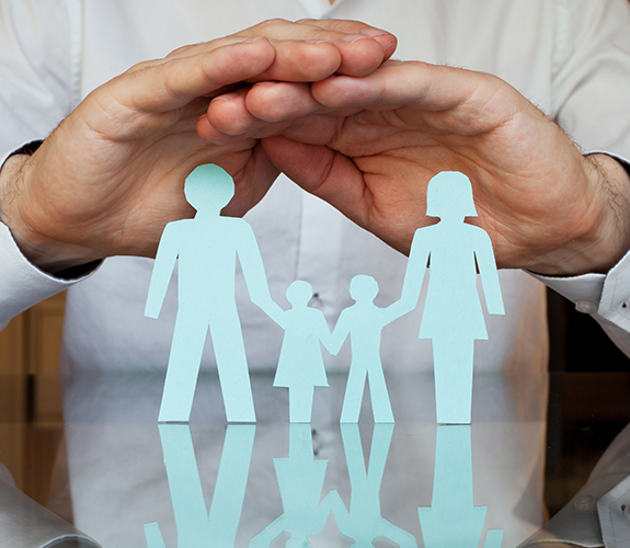 Hands covering a paper cut out family