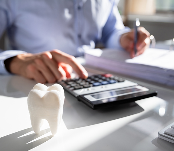 Dentist calculating dental insurance coverage