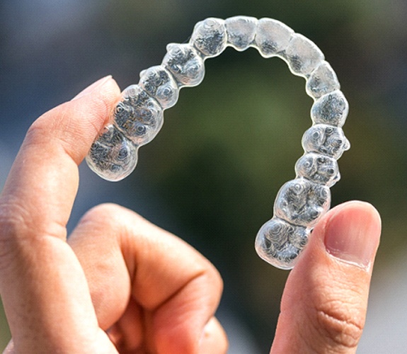 Close-up of hand holding Invisalign in Channahon, IL