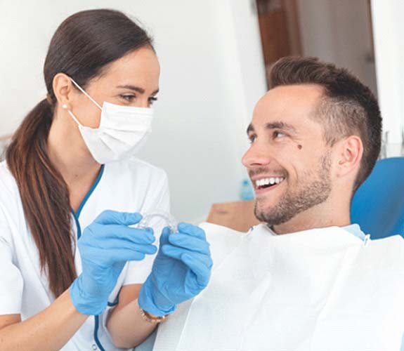 dentist and patient discussing cost of Invisalign in Channahon