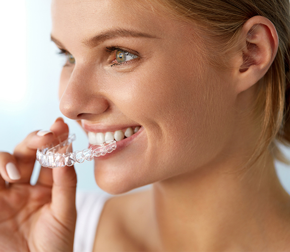 Woman placing her Invisalign clear braces tray