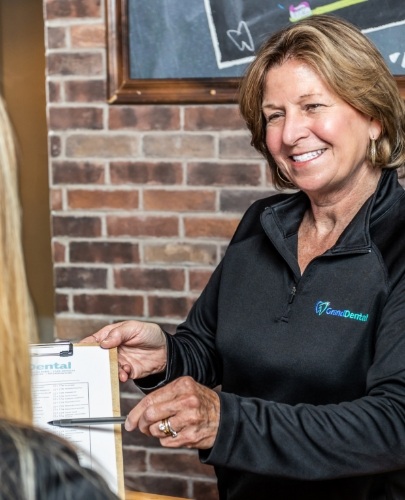 member of dental staff smiling with patient