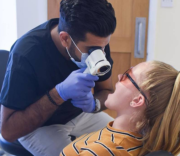 Dentist performing oral cancer screening