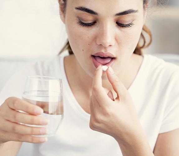 Woman taking oral conscious dental sedation pills