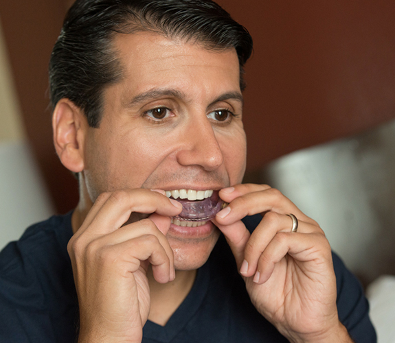 Man placing sleep apnea appliance