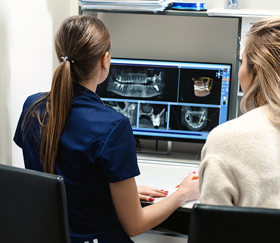 Dentist and dental team member looking at digital x-rays